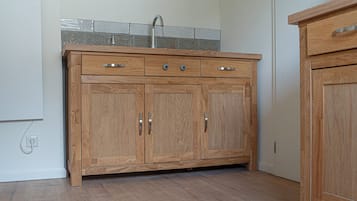 Un meuble en bois avec des tiroirs et un évier intégré.