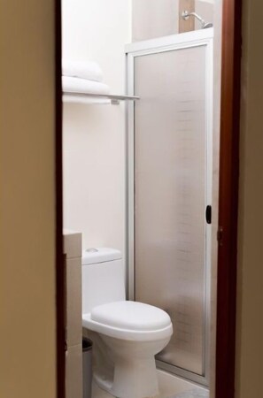 A bathroom with a toilet, a shower enclosure, and a towel rack. - Saules Sueño (Cancún)