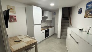 A compact kitchen with a dining area, a built-in oven, and a small sink. - HOUSE OF TOTONN (Unknown)