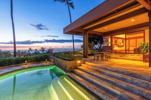 Une maison moderne dotée d’une piscine, d’un espace salon extérieur et offrant une vue sur l’océan.