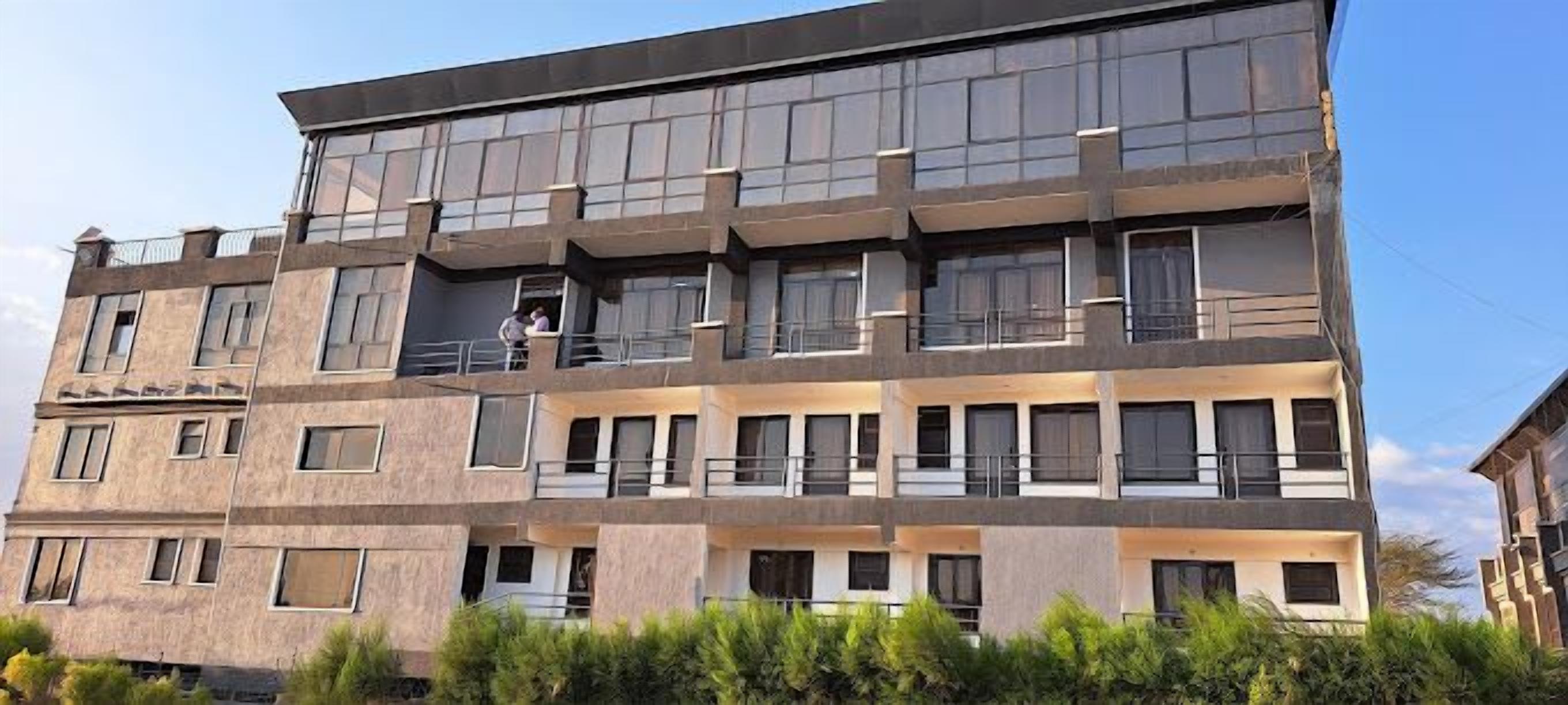 A multi-story building with a modern architectural style, featuring balconies and large windows.