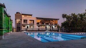 A modern hotel with a swimming pool, a balcony, and a view of the surrounding area. - Wonderland Destinations Resort (Naivasha)