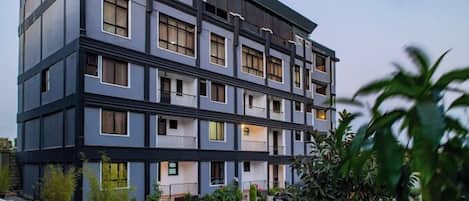 Un edificio de varios pisos con un diseño moderno, con balcones y ventanas amplias.