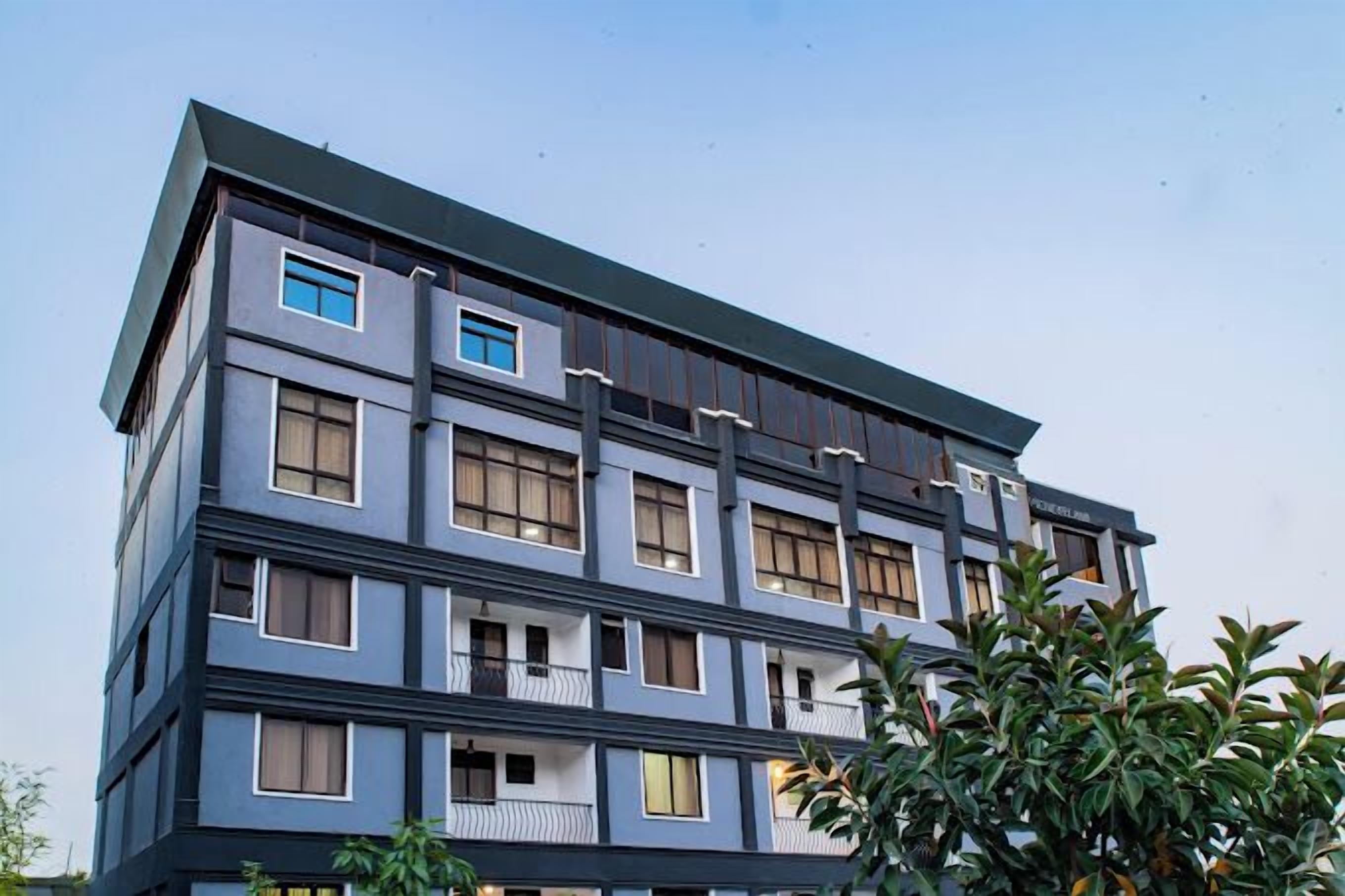 A multi-story building with a modern architectural design, featuring balconies and large windows.