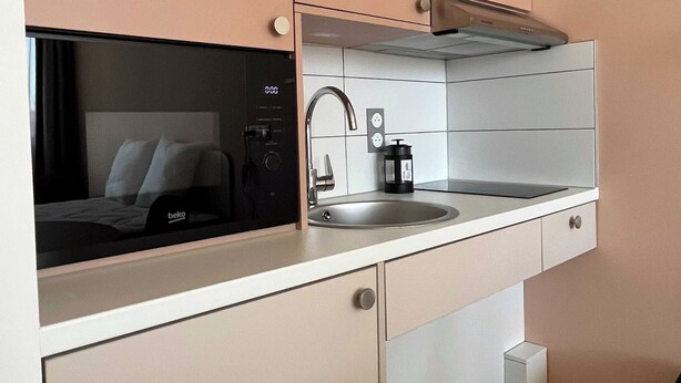 A compact kitchen with a microwave, sink, and stove. - Comfort Studio in a Premium Residence- Sport/cinema (Huningue)