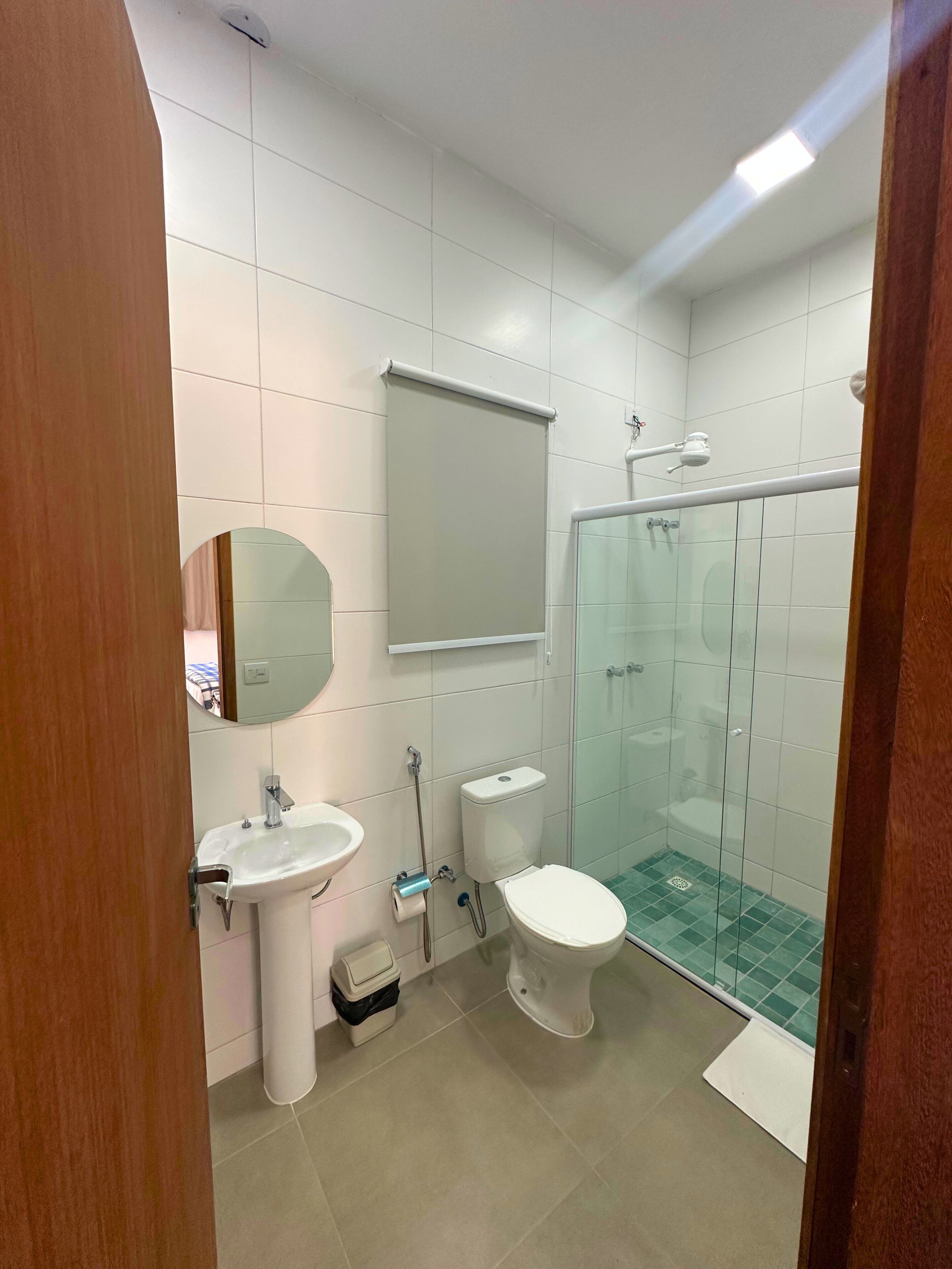 Ein Badezimmer mit Toilette, Waschbecken und einer Duschkabine aus Glas.