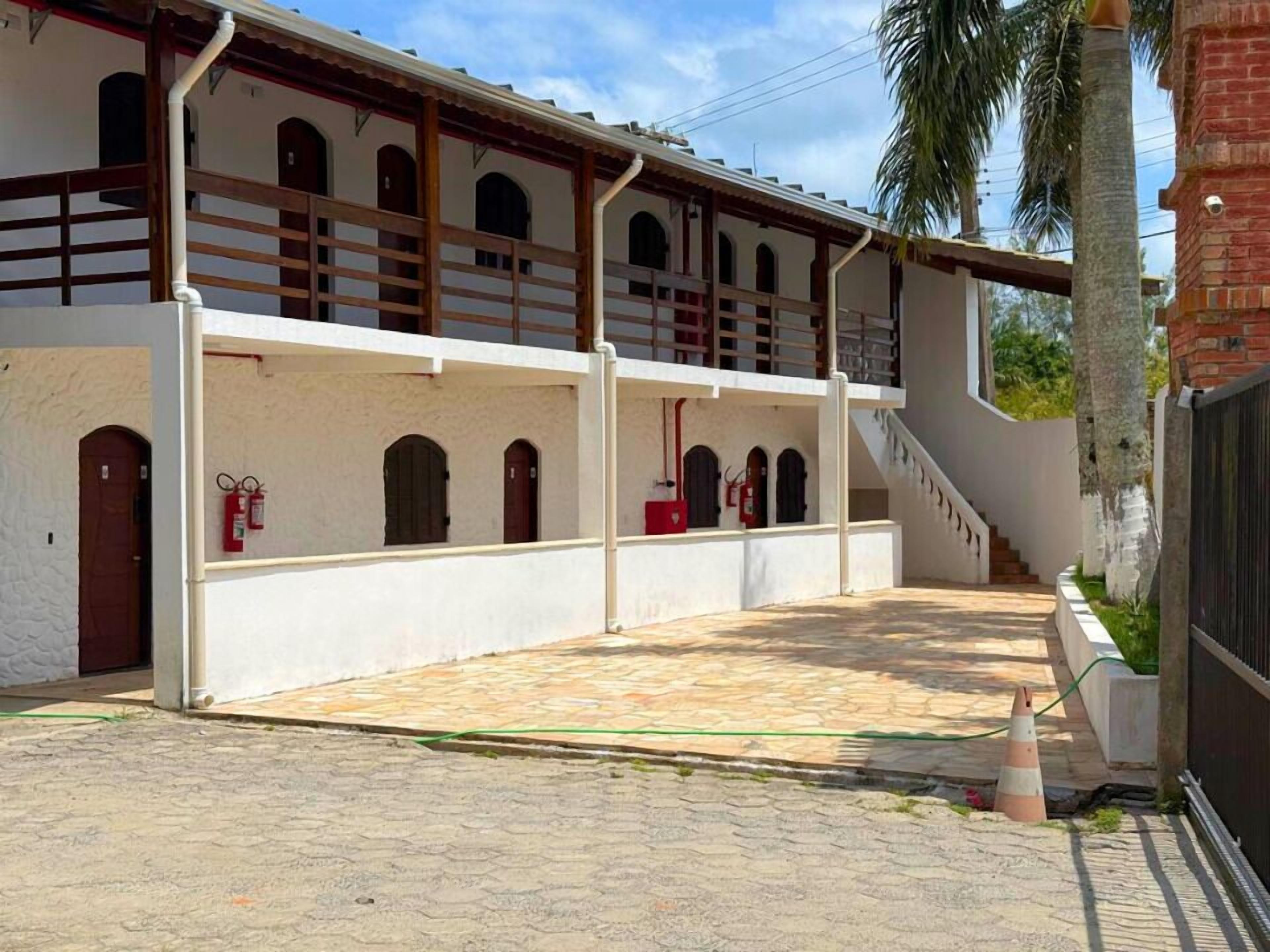 A two-story building with a covered patio area, fire extinguishers, and a staircase leading to the upper level.