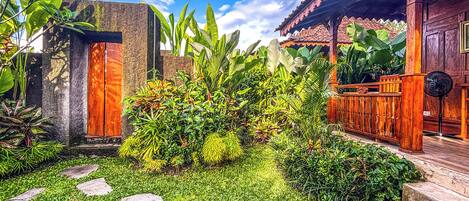 A garden with stone steps, lush greenery, and a wooden structure.
