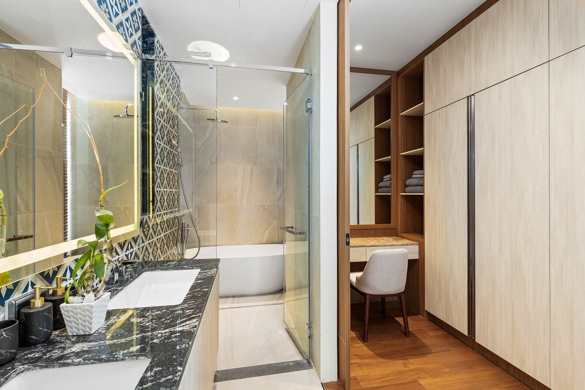 A modern bathroom with a glass shower enclosure, a marble vanity, and a wooden wardrobe with shelves.