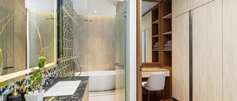 A modern bathroom with a glass shower enclosure, a marble vanity, and a wooden wardrobe with shelves.