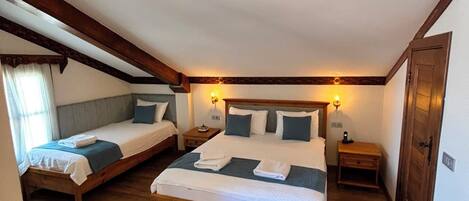 Un dormitorio con dos camas, suelo de madera y techo inclinado.
