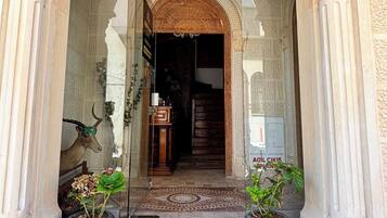 Un ingresso con un arco, ornato da colonne, che conduce a una scala.