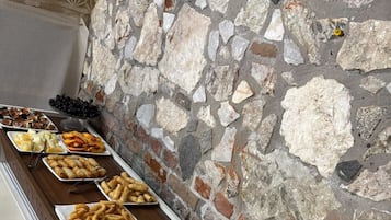Un bufé con diferentes opciones de comida, incluyendo frutas, pasteles y ensaladas.
