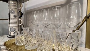 A marble countertop with a gold tray holding six crystal glasses and a decorative container. - UPSCALE EAST TEXAS CABIN, PRIVATE HOT TUB, WIFI, ROKU, OLD MILL VILLAGE KENNARD (Kennard)