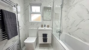 Une salle de bain moderne équipée de toilettes, d’un lavabo et d’une douche.