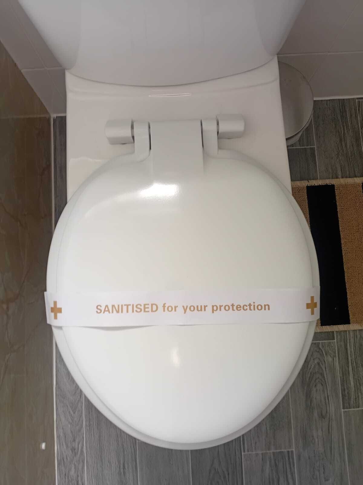 Un bagno con un cartello che riporta: "IGIENIZZATO per la tua sicurezza".