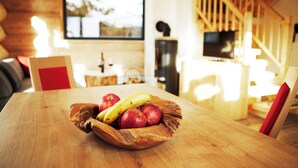 A wooden dining table with a bowl of apples and bananas. - Cosy Chalet with Panoramic View, Sun Terrace and Free Summer Mountain Cable Car (Ladis)