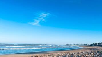 A beach with a clear sky and ocean waves.