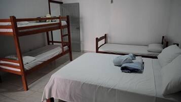Quarto de estudante com duas beliches e uma cama individual.