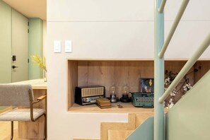 Un interior moderno con un escritorio de madera, una radio antigua y un pequeño estante con objetos decorativos.