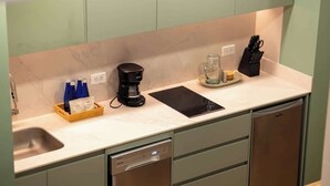 Una cocina moderna con lavavajillas integrado, cafetera y un bloque de cuchillos en la encimera.