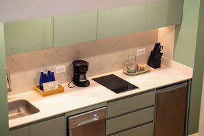 A modern kitchen with a built-in dishwasher, a coffee maker, and a knife block on the countertop. - Digital Nomad Paradise 1BR unit with A/C in Manila (Medellín)
