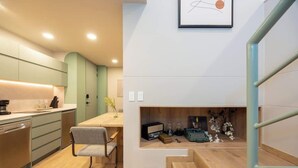 Una cocina moderna con comedor, una escalera y un pequeño rincón con adornos.
