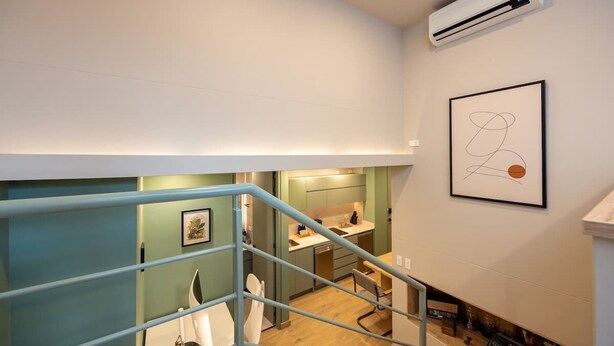 Un apartamento moderno con una escalera que lleva a una zona de cocina.