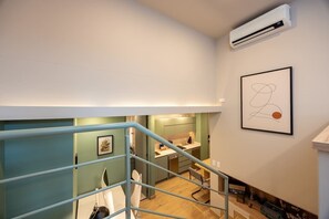 A modern apartment with a staircase leading to a kitchen area. - Digital Nomad Paradise 1BR unit with A/C in Manila (Medellín)
