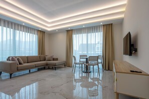 Suite Deluxe, balcón, vistas a la piscina | Zona de estar | Televisión LCD de 43 pulgadas con canales por satélite