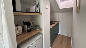 A compact kitchen with a toaster, kettle, and a small refrigerator. There is a skylight above the sink area. - Studio under the roof - Marché (LA ROCHELLE)
