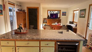 Una cocina con encimera de granito, armarios de madera y un refrigerador para vinos empotrado.