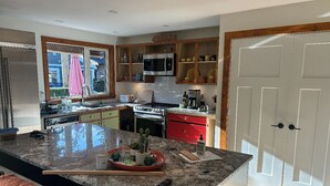 Una cocina con encimeras de granito, microondas integrado y estufa roja.
