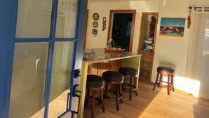 Una cocina con barra, taburetes de madera y un refrigerador.
