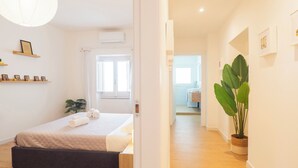 A bedroom with a bed, bedside table, and a potted plant. - Sa Perda e Su Entu - Morada (Iglesias)