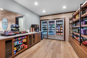 A reception area with a counter, vending machines, and refrigerated beverage dispensers. - Everhome Suites Stockbridge Atlanta (Stockbridge)