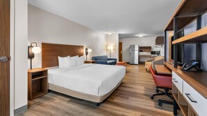 Une chambre d’hôtel équipée d’un lit, d’un bureau, d’une chaise et d’une kitchenette.
