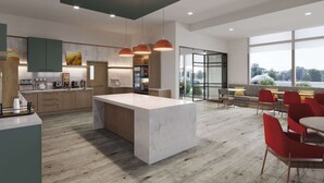 A modern kitchen with a large island, wooden cabinets, and pendant lighting. - Comfort Inn & Suites (Cochrane)