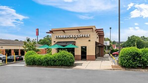 A Starbucks Coffee with a clear sign, a green umbrella, and a parking lot. - Econo Lodge Hickory (Hickory)