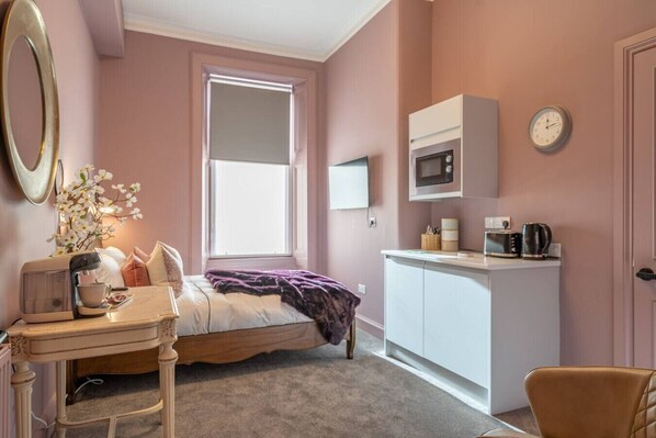 1 habitación, escritorio, tabla de planchar con plancha y cuna de viaje