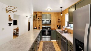 Una cocina moderna con detalles de madera, electrodomésticos de acero inoxidable y una isla central.