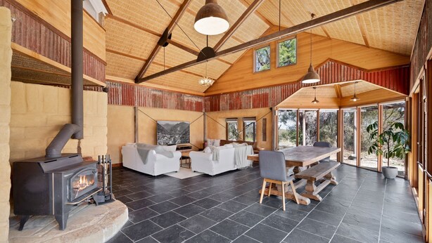 A spacious living area with a fireplace, seating, and large windows. - The Last Straw in Katoomba (Katoomba)