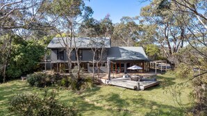 A two-story house with a covered patio and a deck, surrounded by trees and greenery. - The Last Straw in Katoomba (Katoomba)