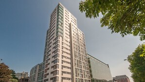 Un immeuble moderne de grande hauteur, doté d’une façade en verre et de nombreux étages.