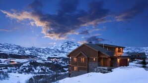 A wooden house with a stone foundation, surrounded by snow-covered mountains and a clear sky. - Deer Valley  Lakeside Ski House *Sleeps 16 Free Ski Shuttle- Minutes to Deer Valley East Village and Jordanelle Reservoir (Heber City)