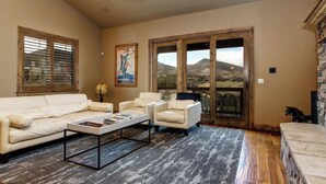 A living room with a beige sofa, two armchairs, a coffee table, and a large window with a view of mountains. - Deer Valley  Lakeside Ski House *Sleeps 16 Free Ski Shuttle- Minutes to Deer Valley East Village and Jordanelle Reservoir (Heber City)