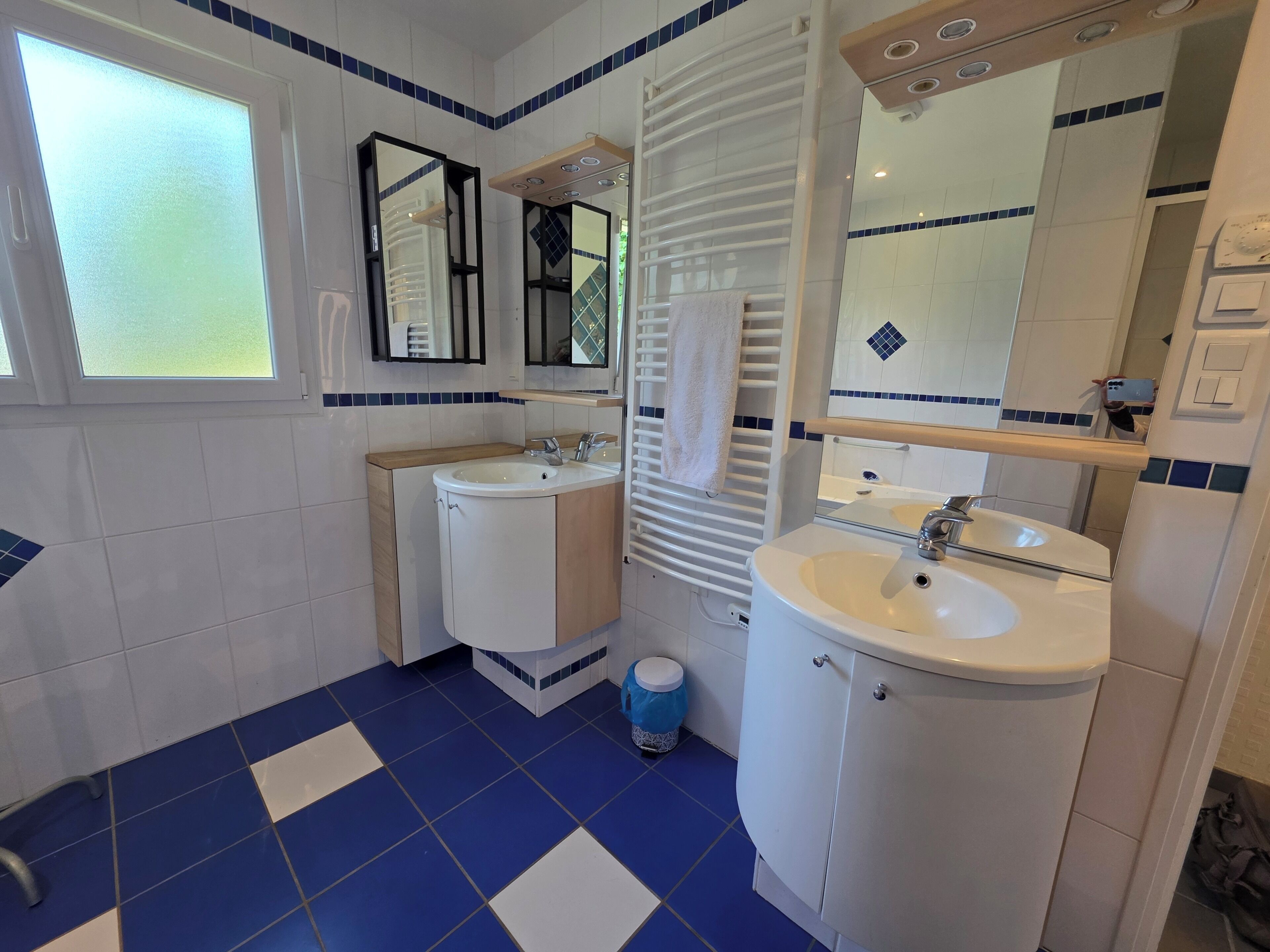 A bathroom with two sinks, a mirror, and a window.