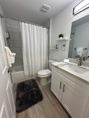 Une salle de bain moderne avec une baignoire, des toilettes et un lavabo.