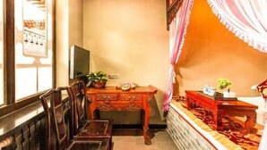 A bedroom with a bed, a wooden desk, a chair, a television, and a window with curtains. - Yongshengyuan Courtyard Retro Courtyard Inn (Pingyao Ancient City Branch) (Pingyao County)