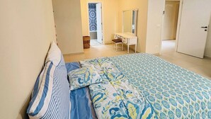 Un dormitorio con cama, cómoda, espejo y equipo de aire acondicionado.